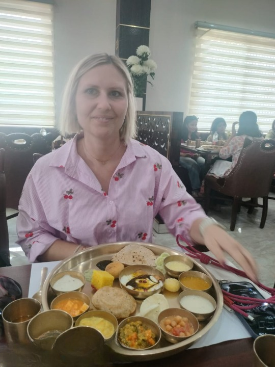 Turista straniero che gusta una tradizionale thali indiana durante un viaggio culturale in India