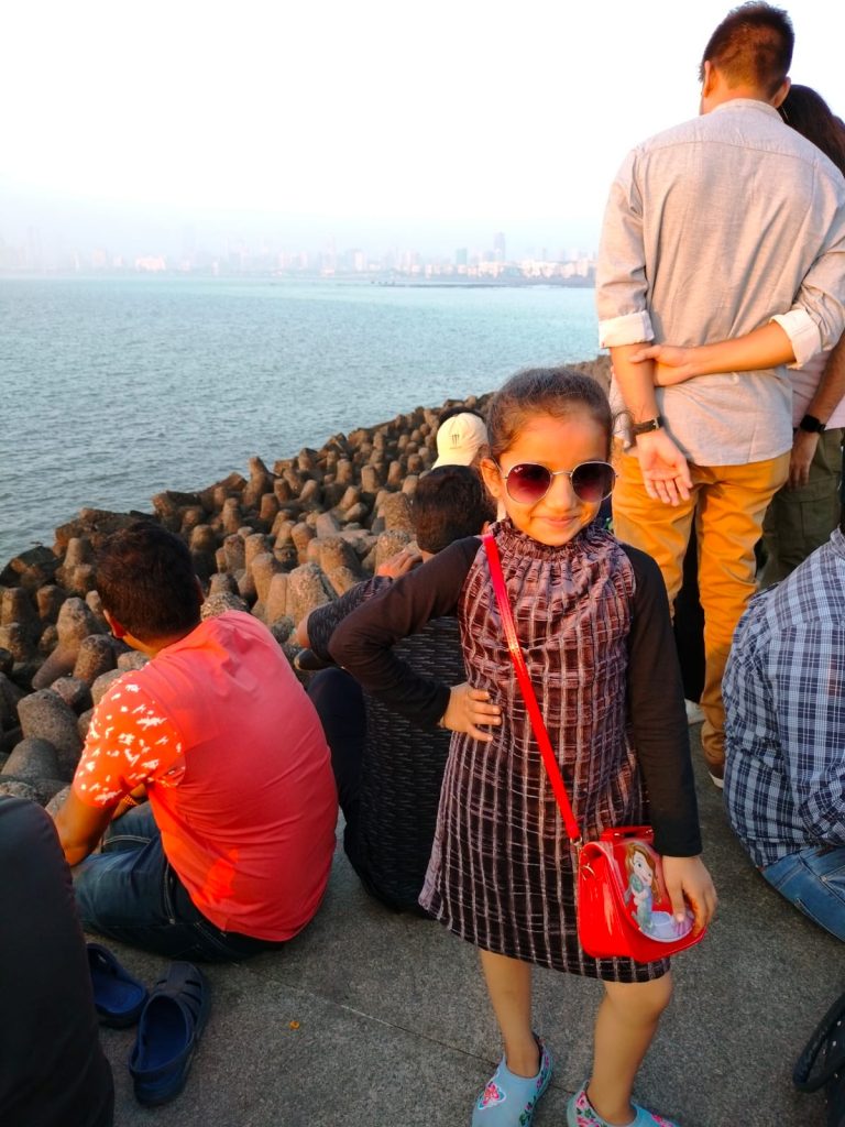 Un bambino passeggia sul Marine Drive di Mumbai durante una vacanza in India.