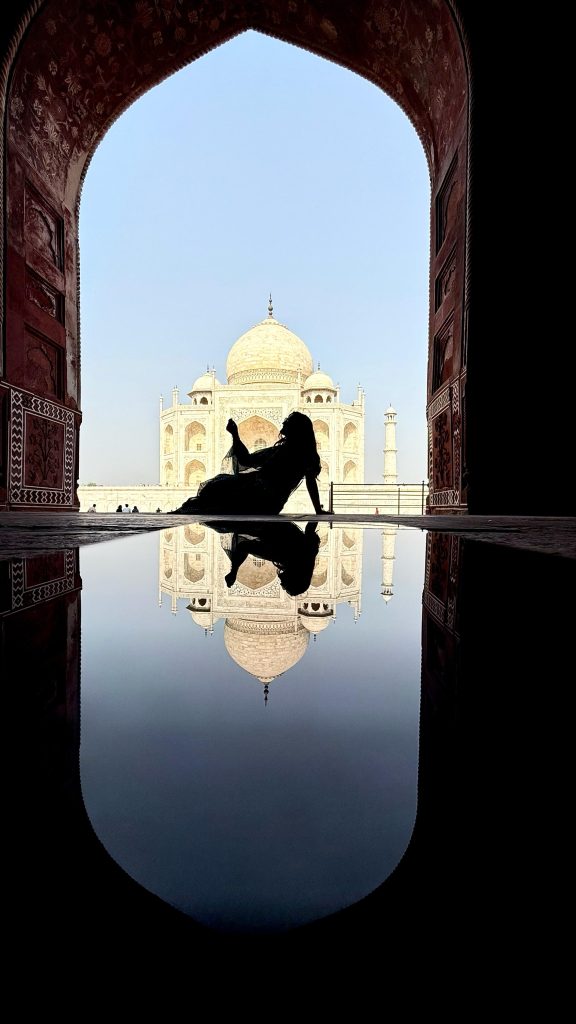 Ragazza italiana in posa davanti al Taj Mahal ad Agra durante un viaggio in India