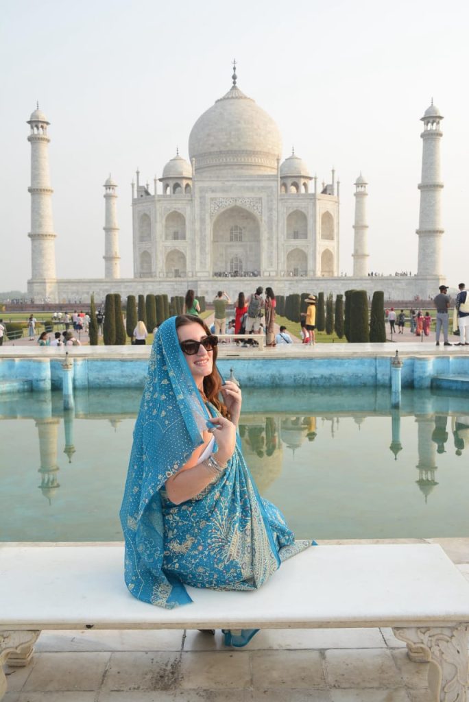 Donna italiana in sari davanti al Taj Mahal durante un viaggio in India